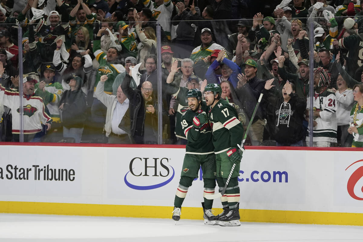 Minnesota Wild left wing Marcus Foligno (17) celebrates with center Frederick Gaudreau (89) aft ...