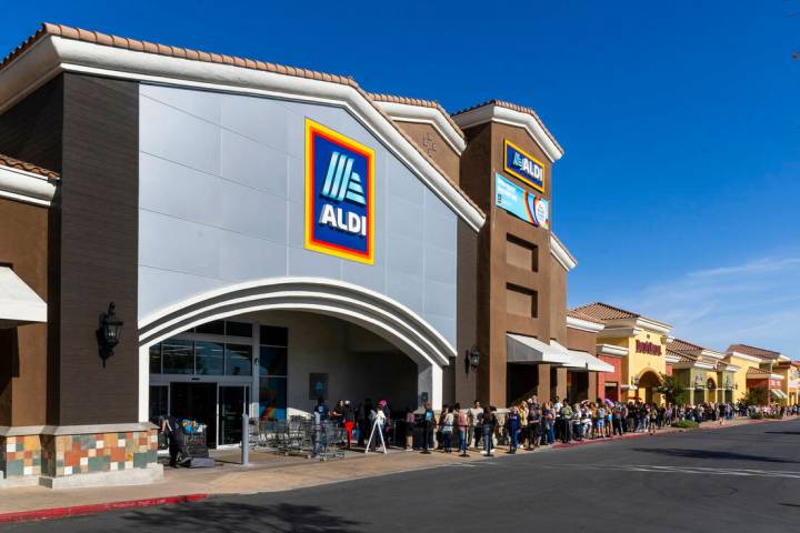 A line of customers waiting to enter stretches down the shopping center complex as Aldi is offi ...