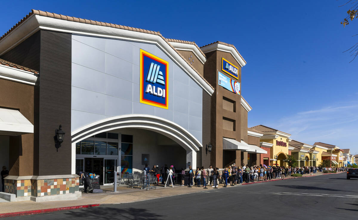 A line of customers waiting to enter stretches down the shopping center complex as Aldi is offi ...