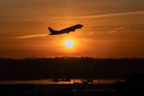 An airplane lifts off from Ronald Reagan Washington National Airport as the sun rises Monday, F ...