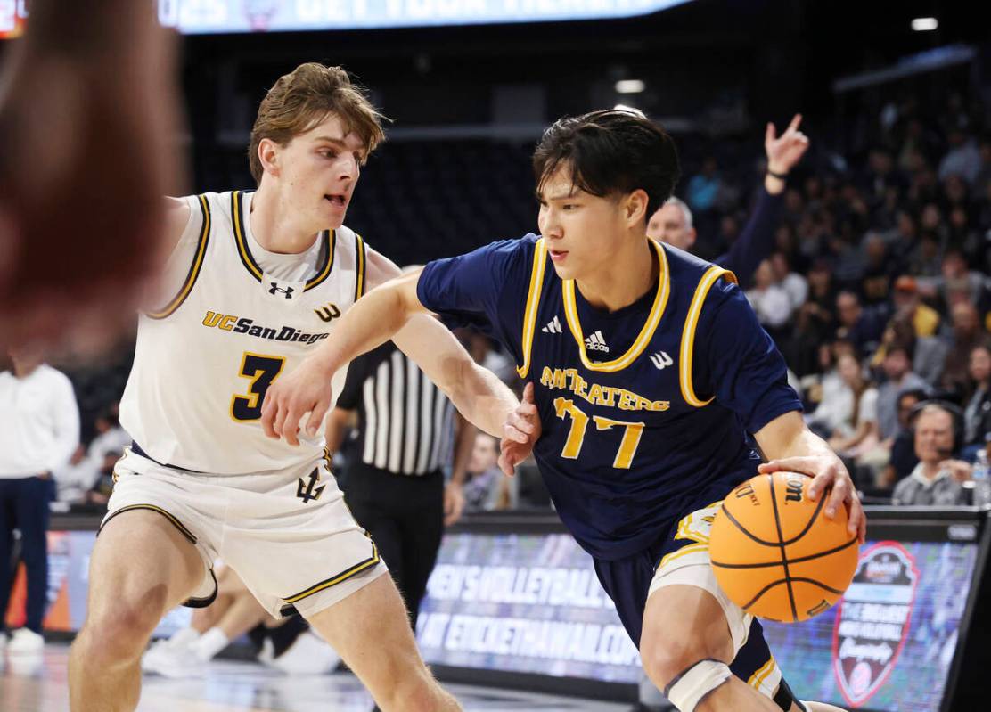 UC Irvine guard Myles Che (77) drives the ball near UC San Diego guard Hayden Gray (3) during t ...