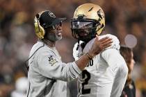 Colorado head coach Deion Sanders, left, talks with quarterback Shedeur Sanders (2) during a ti ...