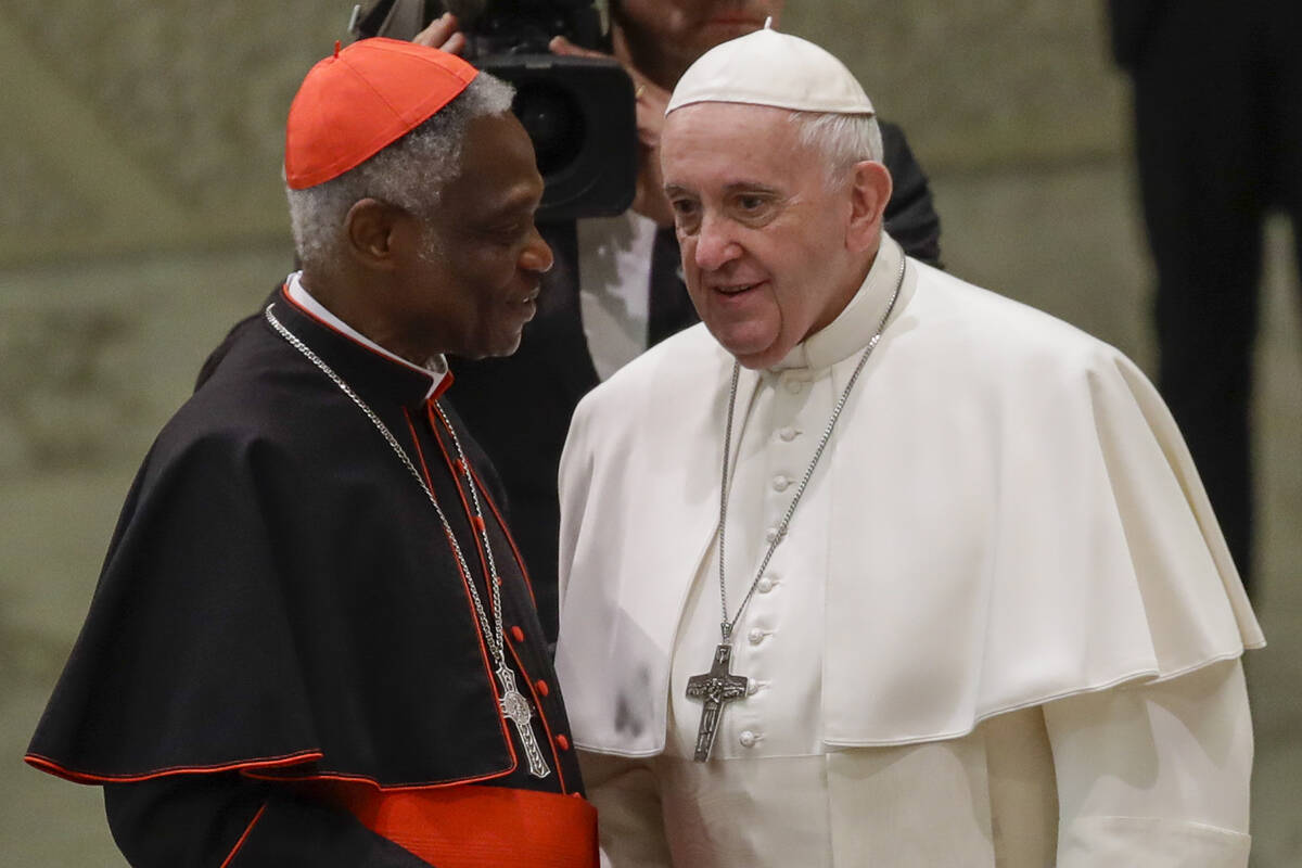 Pope Francis talks with Cardinal Peter Kodwo Appiah Turkson during his weekly general audience, ...