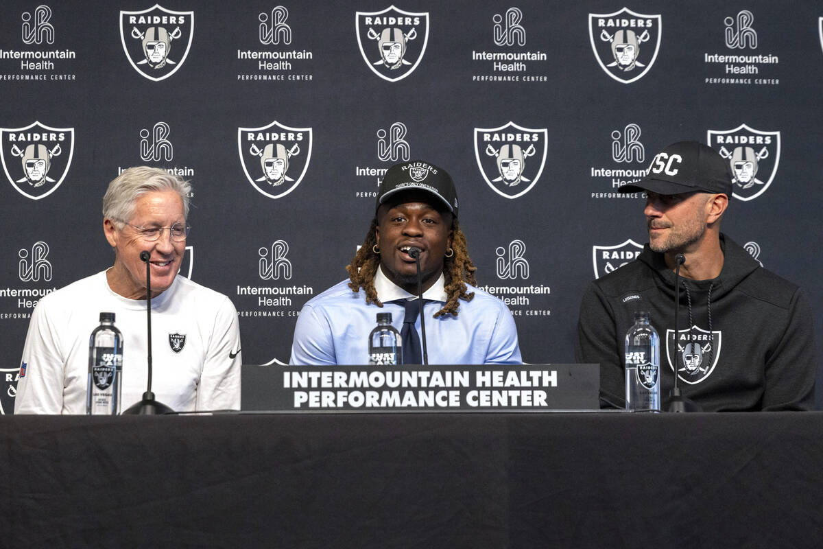 Raiders running back Ashton Jeanty, center, answers questions from media as head coach Pete Car ...