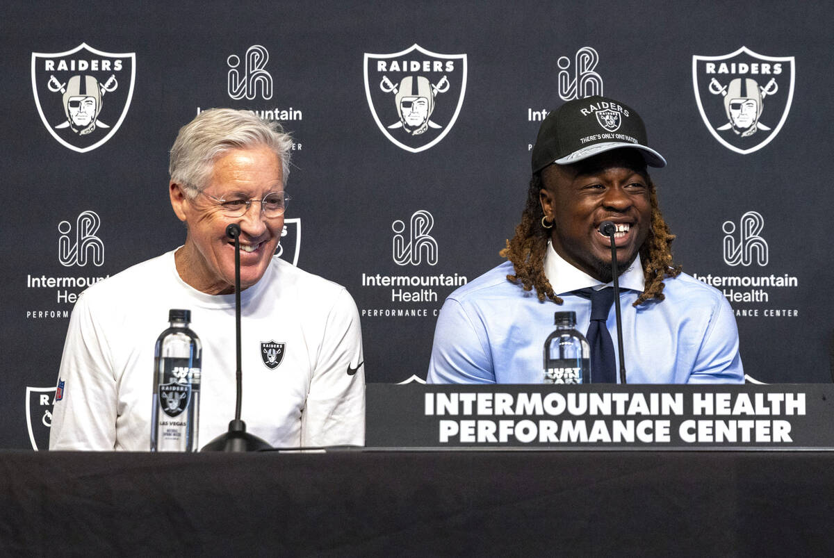 Raiders running back Ashton Jeanty, center, shares a laugh with head coach Pete Carroll as he i ...