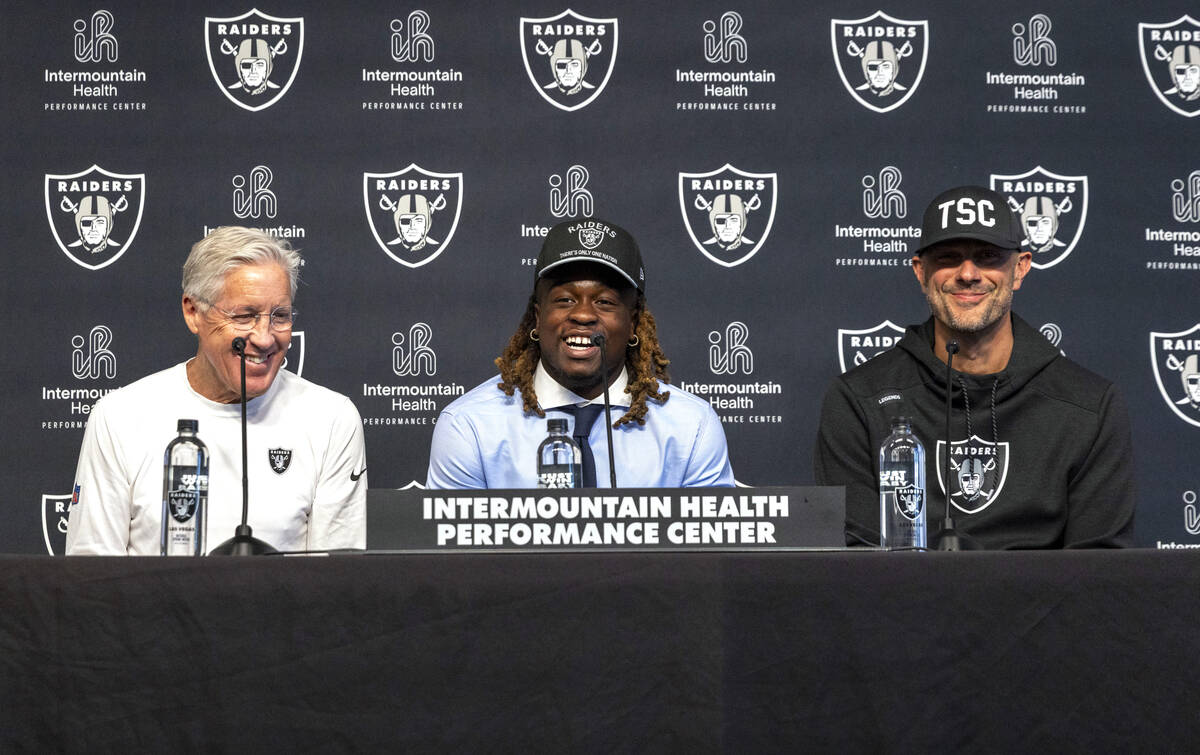 Raiders running back Ashton Jeanty, center, smiles as head coach Pete Carroll, left, and John S ...
