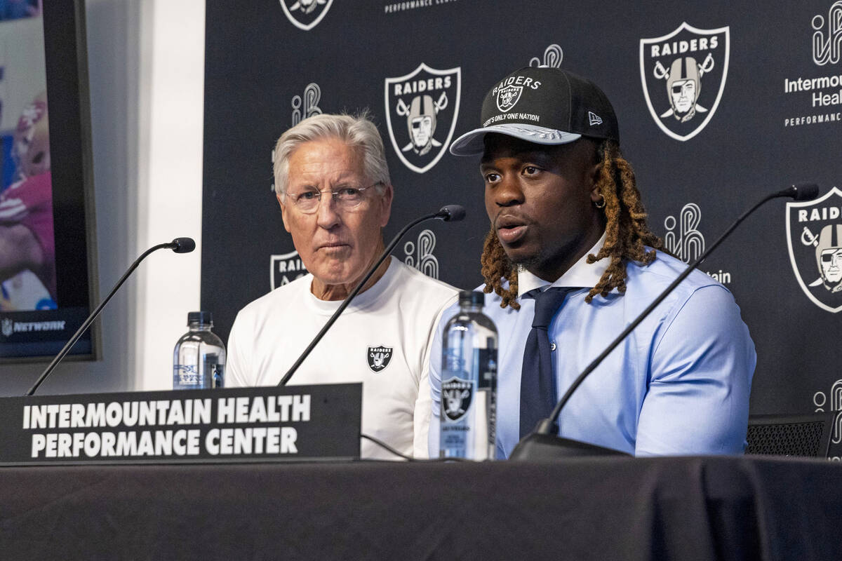Raiders head coach Pete Carroll, left, looks on as first-round draft pick, running back Ashton ...