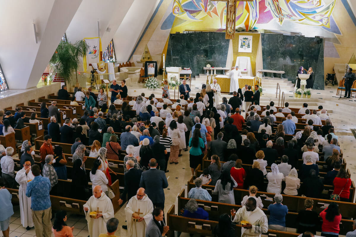 Priests from around the Archdiocese of Las Vegas give Holy Communion to congregants on Friday, ...