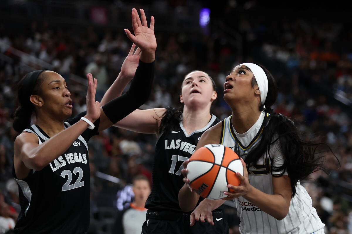 Chicago Sky forward Angel Reese, right, shoots against Las Vegas Aces center A'ja Wilson (22) a ...