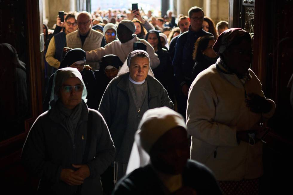 People line up as they enter St. Peter's Basilica to pay their respects to Pope Francis lying i ...