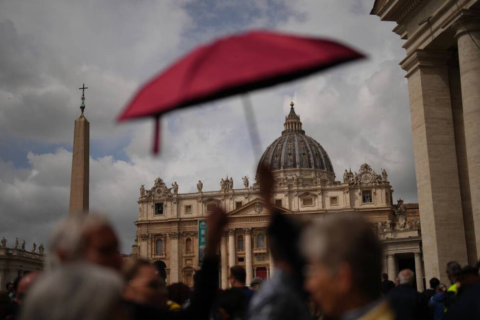 People wait in line under the rain to enter St.Peter's Basilica to view Pope Francis lying in s ...