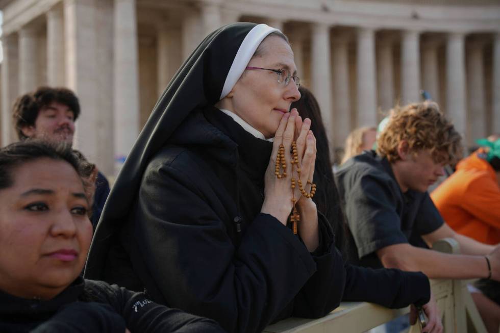 A nun prays as she waits for the funeral of Pope Francis to begin, in St. Peter's Square at the ...