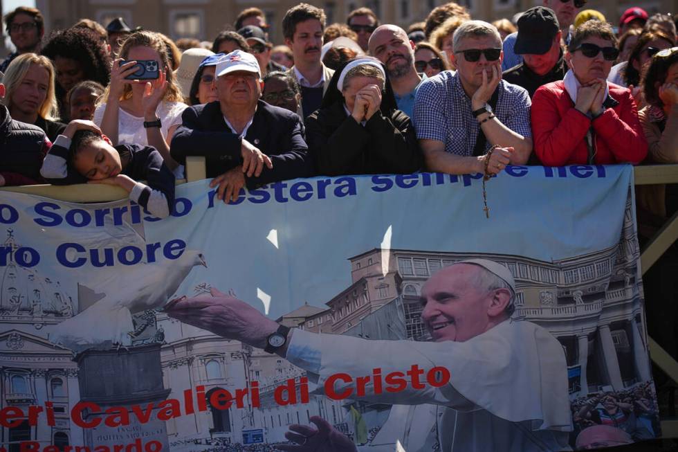 Faithful listen to mass during the funeral of Pope Francis in St. Peter's Square at the Vatican ...