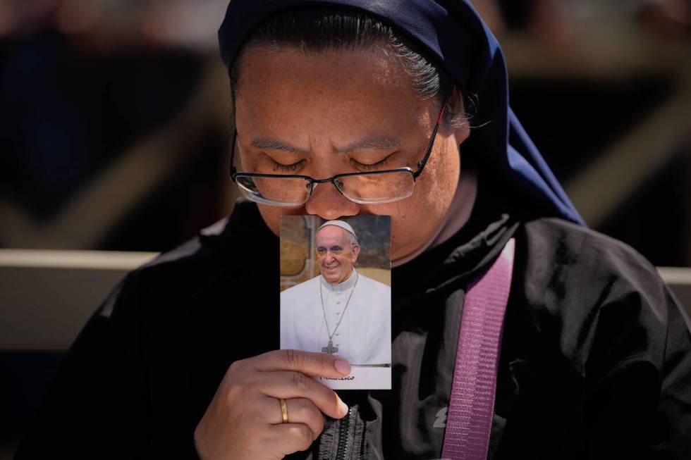 A nun holds a phot of Pope Francis while attending his funeral in St. Peter's Square at the Vat ...