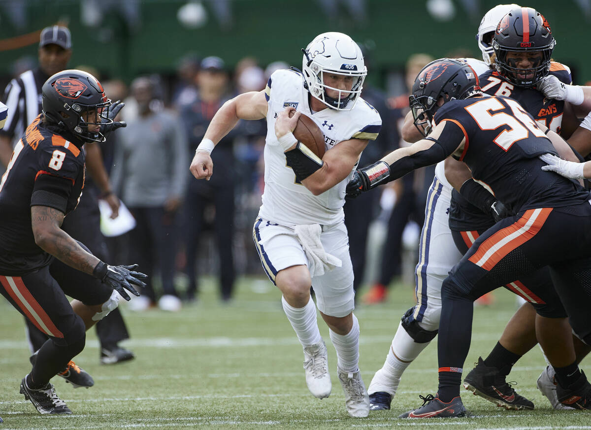 Montana State quarterback Tommy Mellott, center, runs past Oregon State linebacker Kyrei Fisher ...