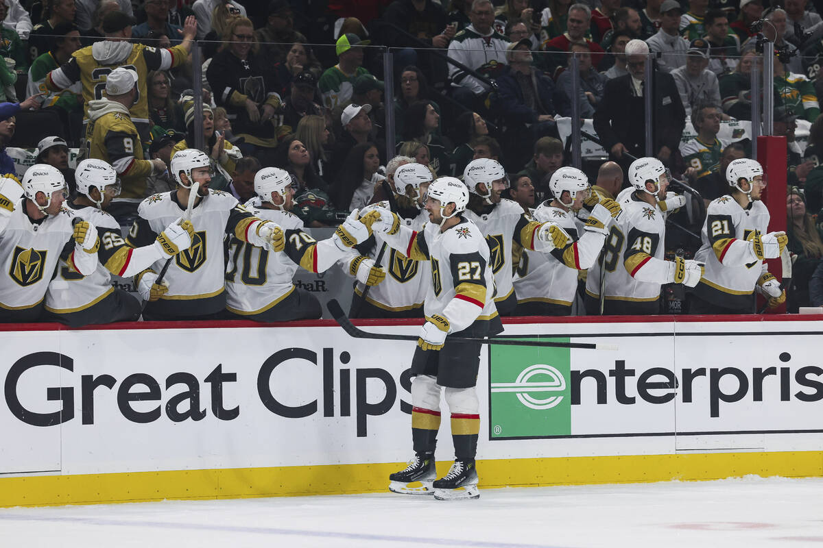 Vegas Golden Knights defenseman Shea Theodore (27) high-fives teammates after scoring a goal ag ...