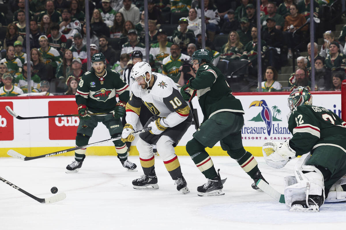 Vegas Golden Knights center Nicolas Roy (10) fights for the puck against Minnesota Wild defense ...