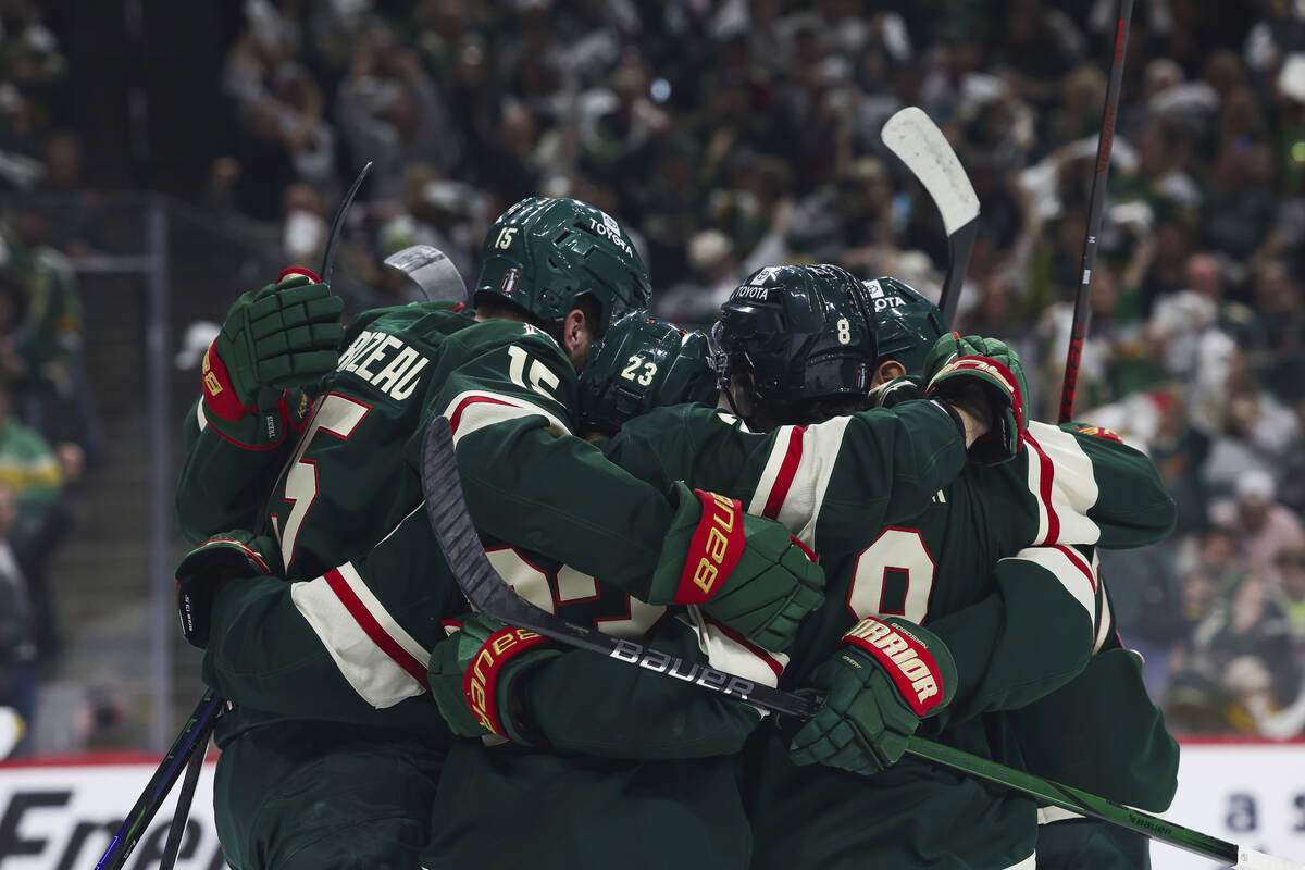 Minnesota Wild center Marco Rossi (23) is surrounded by teammates in celebration after scoring ...