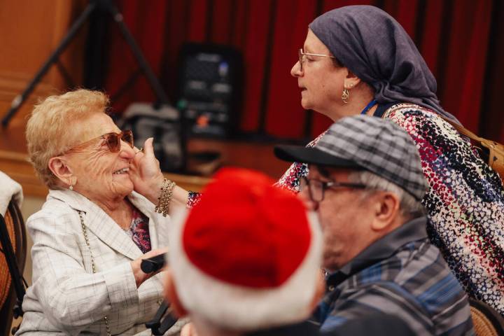 Hana Ivashkov, left, who is a survivor of the Holocaust, sits at a table during a Yom HaShoah c ...