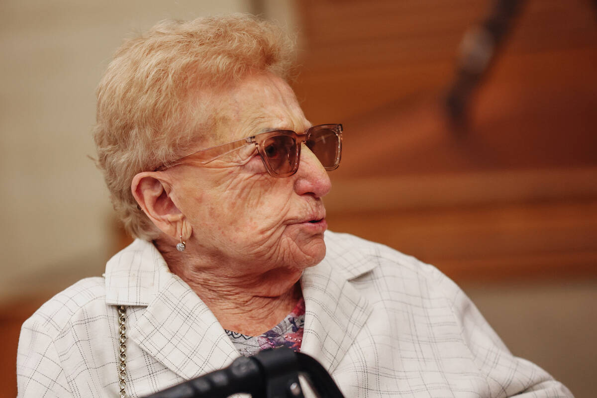 Hana Ivashkov, who is a survivor of the Holocaust, sits at a table during a Yom HaShoah communi ...