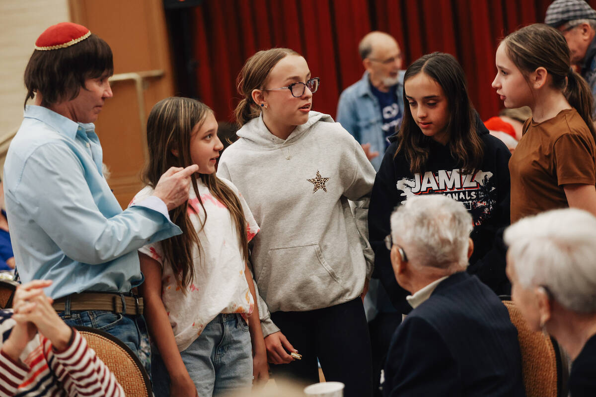 People listen to stories from holocaust survivors during a Yom HaShoah community remembrance at ...