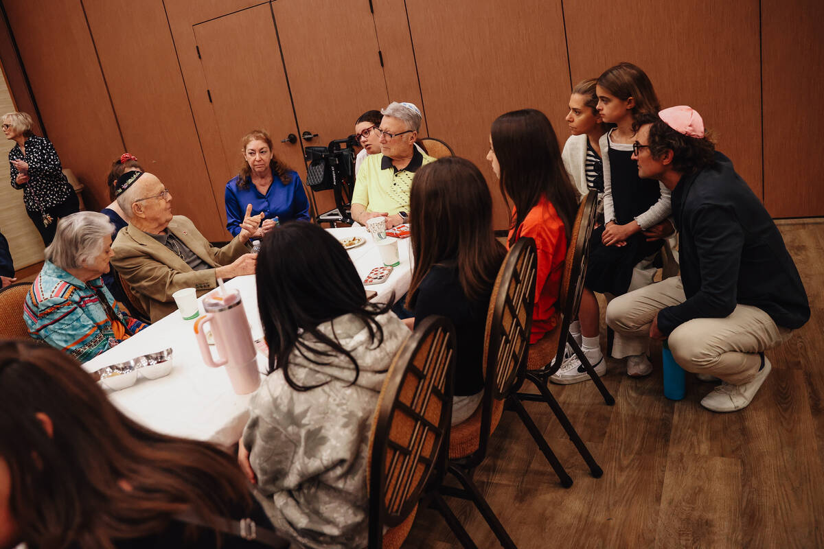 People listen to stories from holocaust survivors during a Yom HaShoah community remembrance at ...