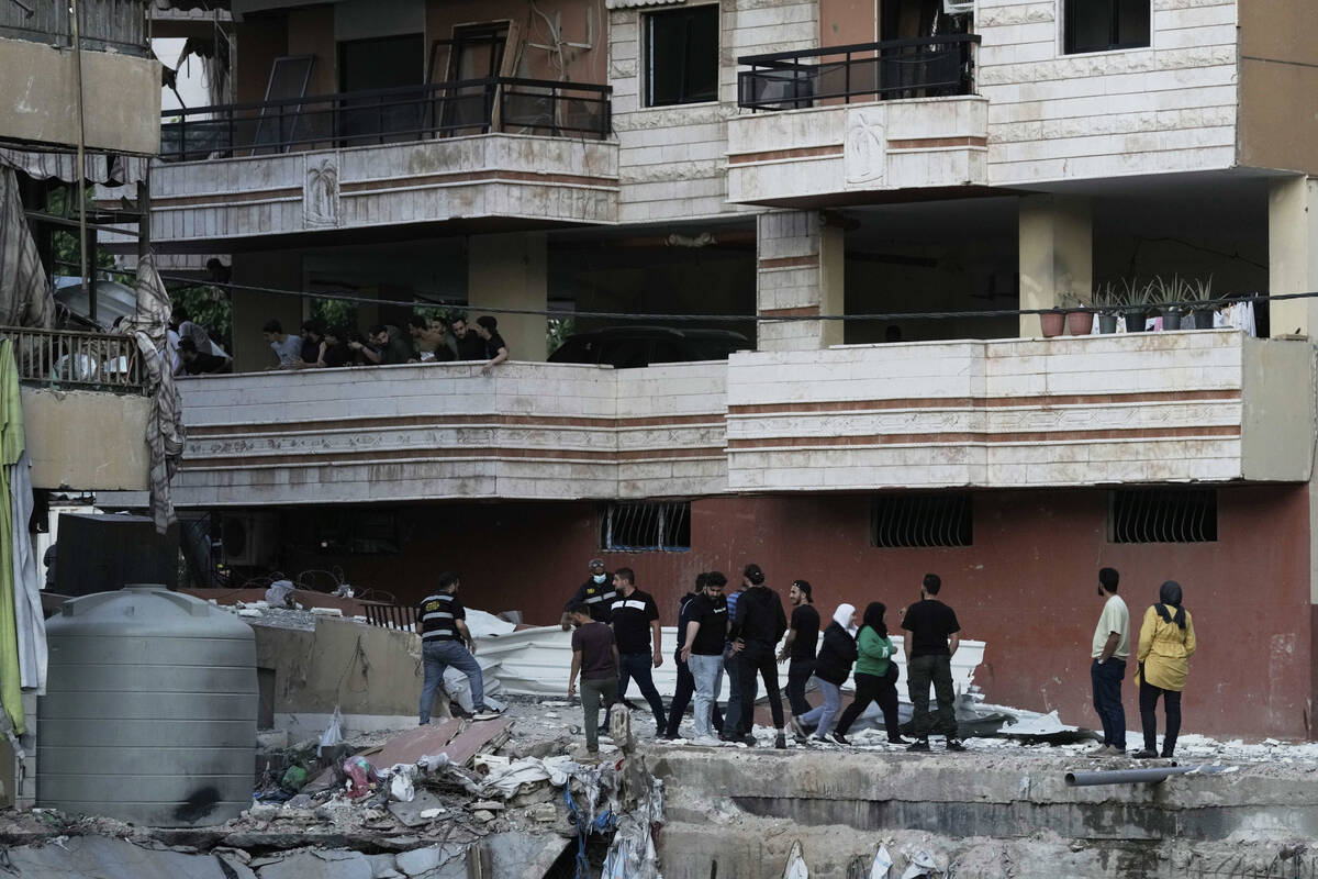 Residents inspect the area following an Israeli airstrike on Dahiyeh in the southern suburb of ...