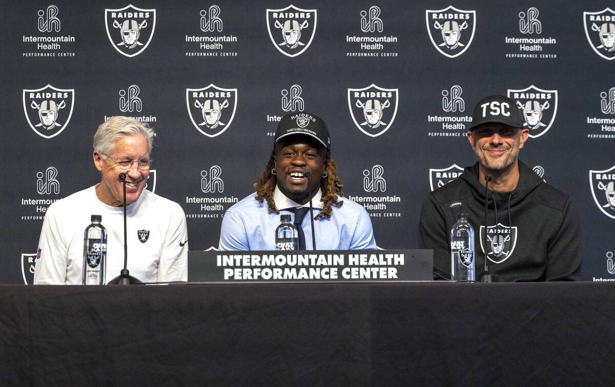 Raiders running back Ashton Jeanty, center, smiles as head coach Pete Carroll, left, and John S ...