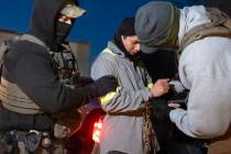 U.S. Immigration and Customs Enforcement officers use a chain to more comfortably restrain a de ...