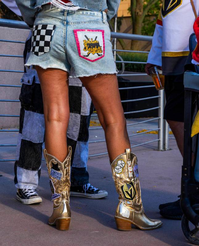 A Golden Knights fan sports golden boots and custom shorts while outside before game five again ...