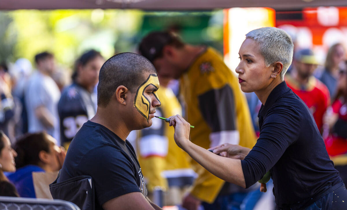 A Golden Knights fan has his face painted while outside before game five against the Minnesota ...