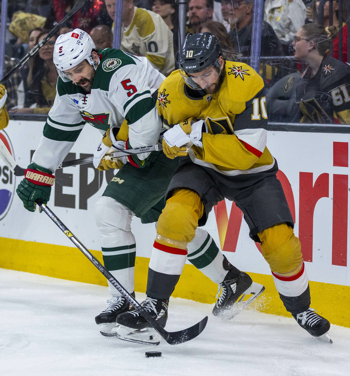 Golden Knights center Nicolas Roy (10) and Minnesota Wild defenseman Jake Middleton (5) fight f ...