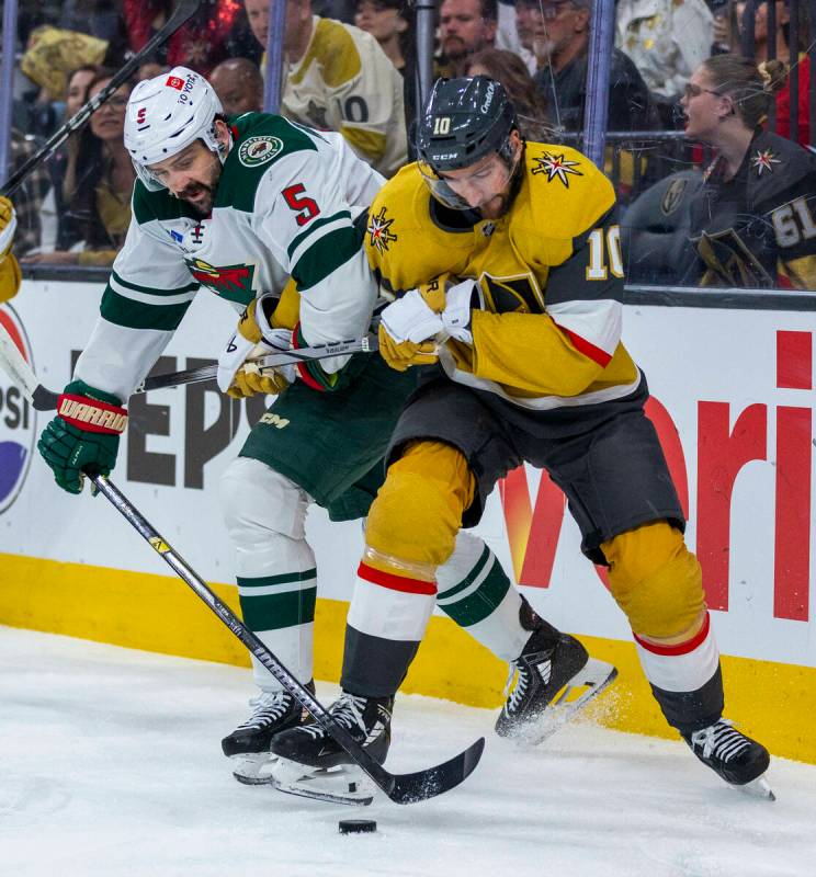 Golden Knights center Nicolas Roy (10) and Minnesota Wild defenseman Jake Middleton (5) fight f ...