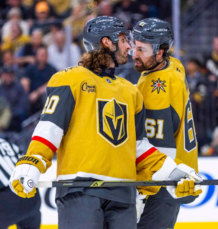 Golden Knights left wing Brandon Saad (20) and right wing Mark Stone (61) confer before another ...
