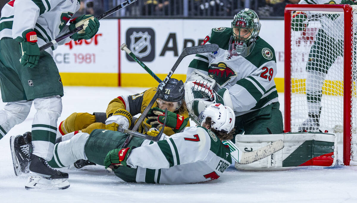 Golden Knights center William Karlsson (71) crashes into Minnesota Wild defenseman Brock Faber ...