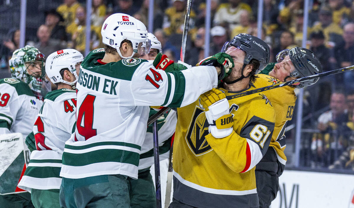 Golden Knights right wing Mark Stone (61) takes a punch to the face from Minnesota Wild center ...