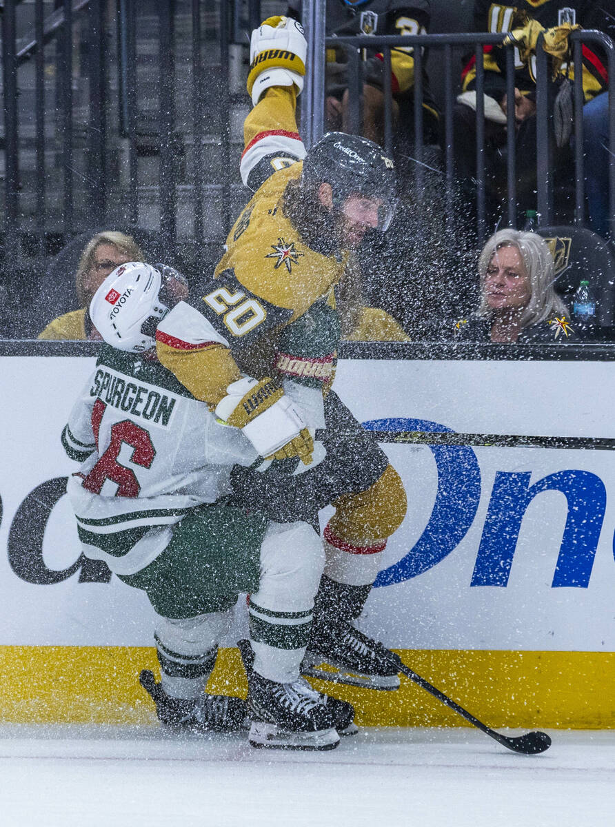 Golden Knights left wing Brandon Saad (20) is grabbed from behind by Minnesota Wild defenseman ...