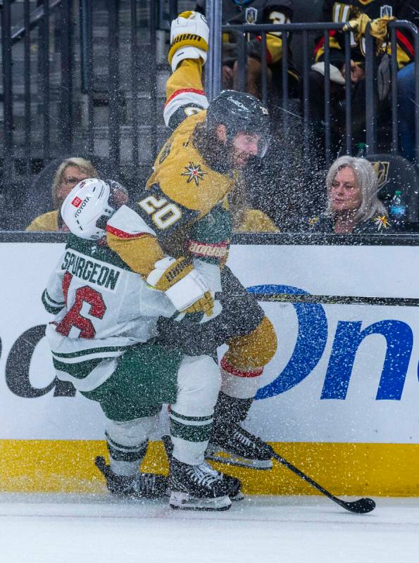 Golden Knights left wing Brandon Saad (20) is grabbed from behind by Minnesota Wild defenseman ...