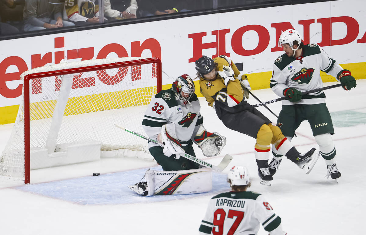 Golden Knights center William Karlsson (71) gets tripped up as Minnesota Wild goaltender Filip ...