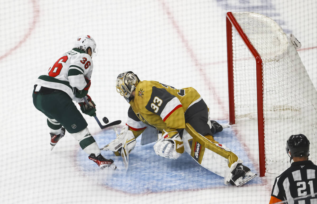 Golden Knights goaltender Adin Hill (33) slides to block a shot from Minnesota Wild right wing ...