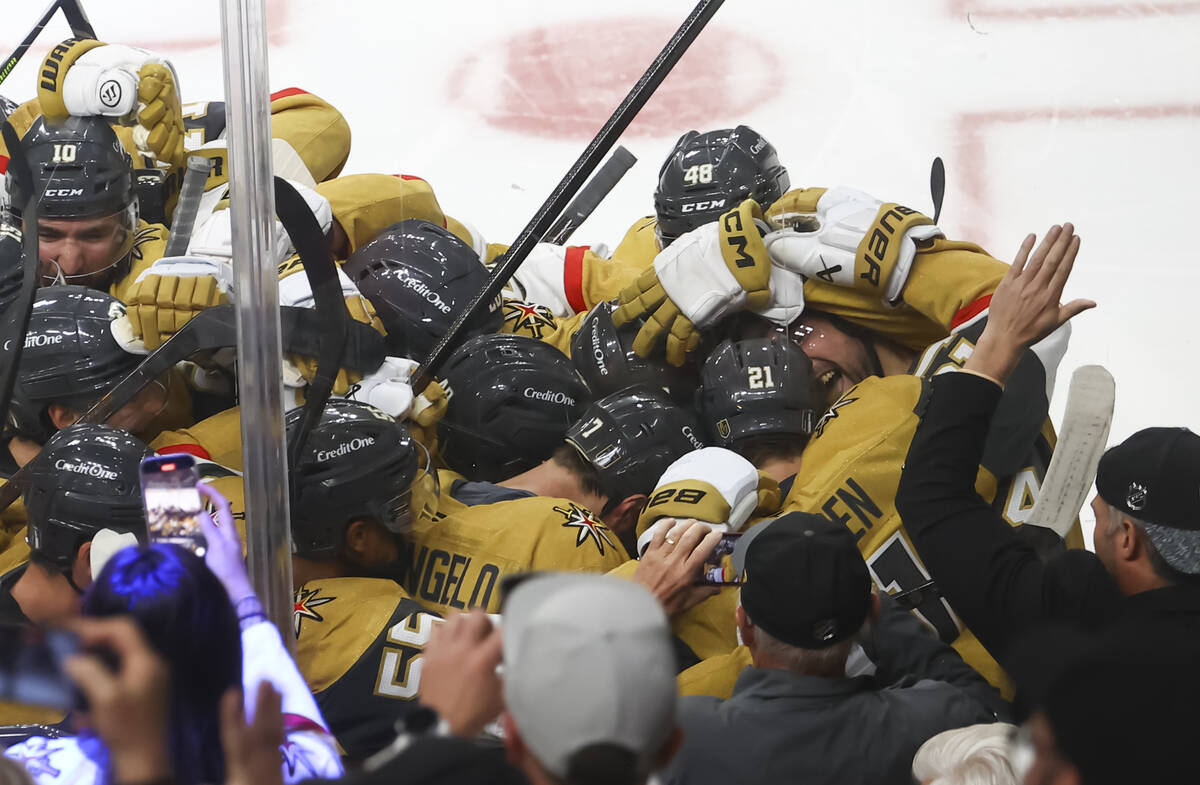Golden Knights center Brett Howden (21) gets mobbed by teammates after his game-winning goal ag ...