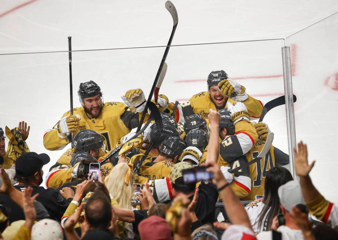Golden Knights center Brett Howden (21) gets mobbed by teammates after his game-winning goal ag ...