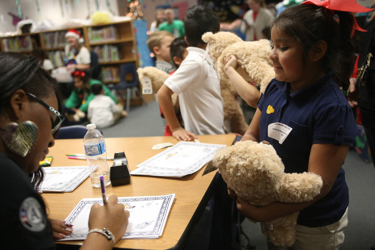 Please Johnson, with Americorp, helps Lisbeth Ramon San Pedro with her stuffed bear's birth cer ...