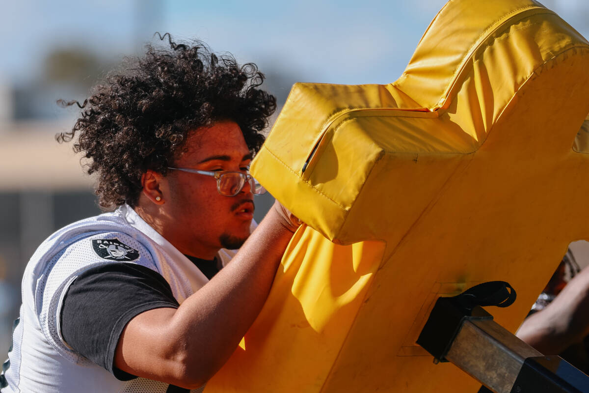 Clark High School offensive lineman Dominic Harris pushes against a drill dummy at practice on ...