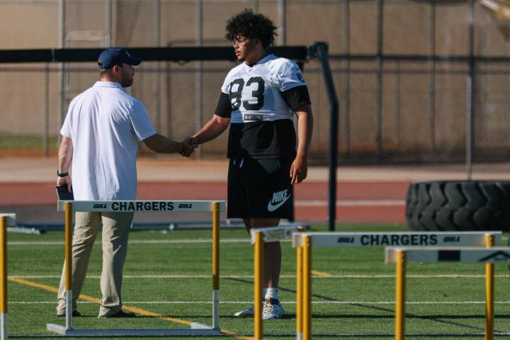 Clark High School offensive lineman Dominic Harris shakes hands with a recruiter at practice on ...