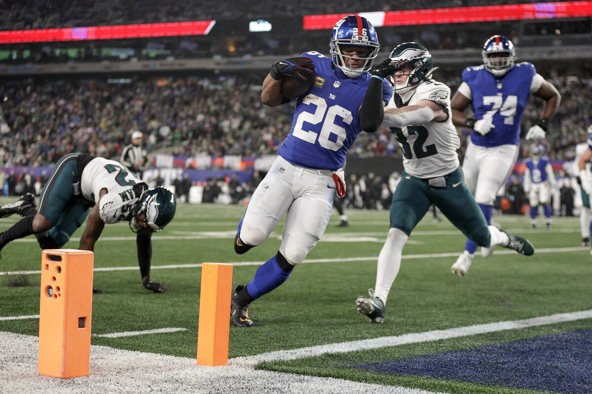 New York Giants running back Saquon Barkley (26) carries the ball into the end zone for a touch ...