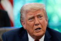 President Donald Trump speaks with reporters after signing executive orders in the Oval Office ...