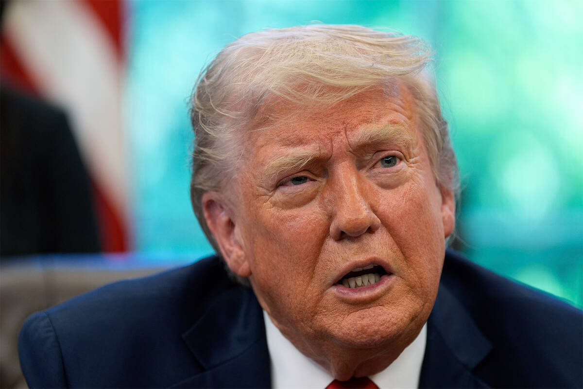 President Donald Trump speaks with reporters after signing executive orders in the Oval Office ...