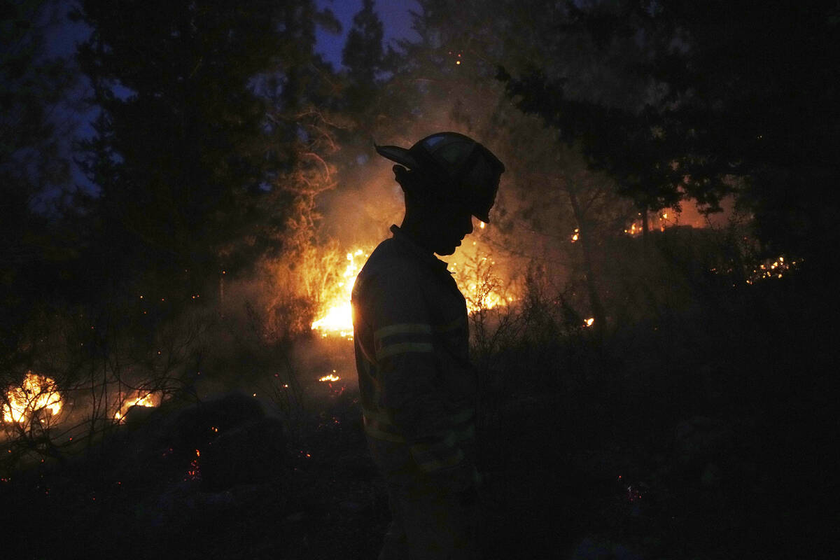 An Israeli firefighter works as forest fire is burning near Jerusalem, Wednesday, April 30, 202 ...