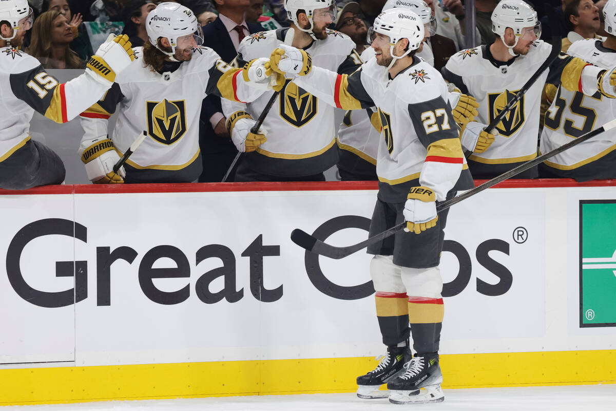 Vegas Golden Knights defenseman Shea Theodore (27) is congratulated by teammates after scoring ...